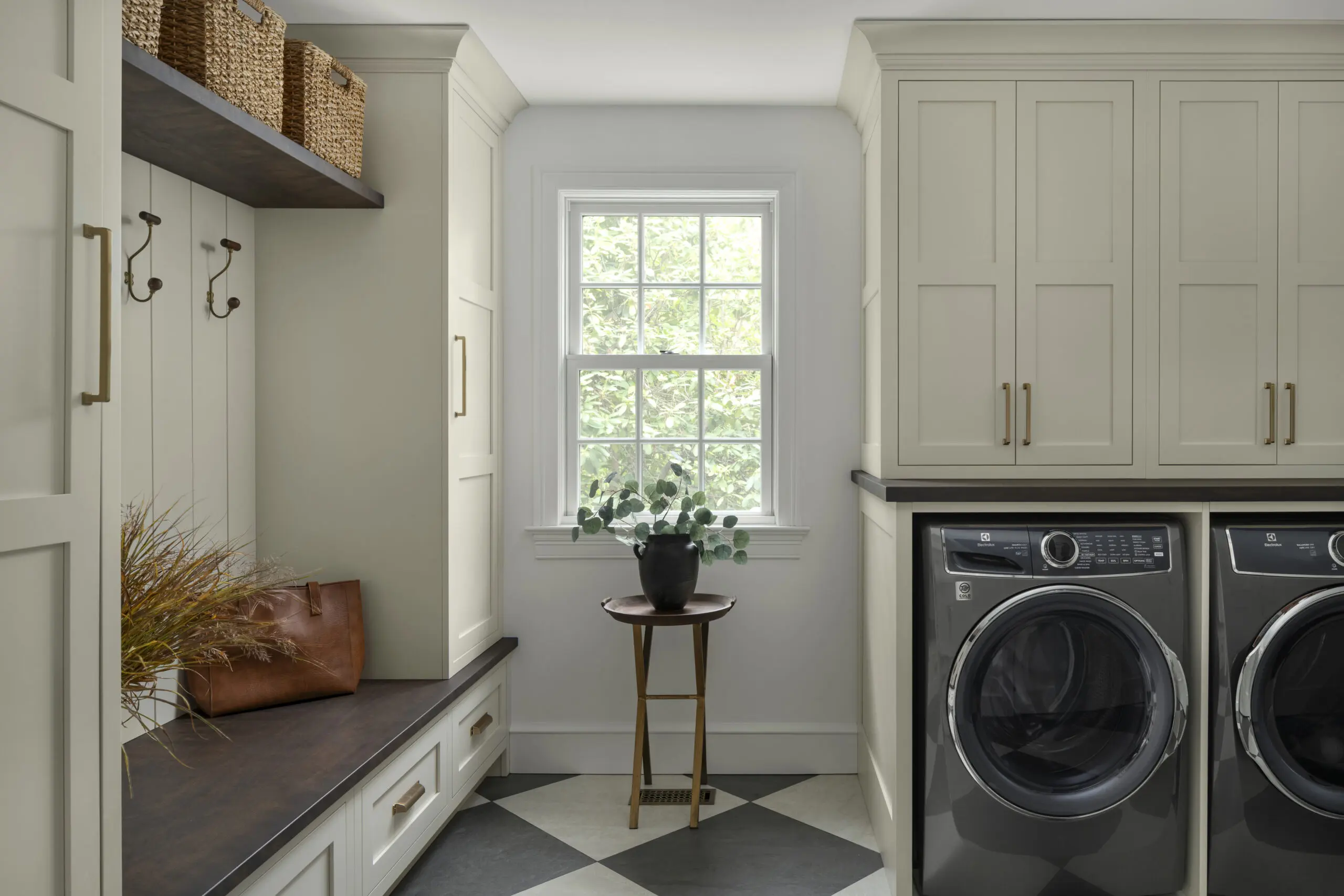 Laundry room cabinetry with upper cabinets, hidden hampers, and hanging rods