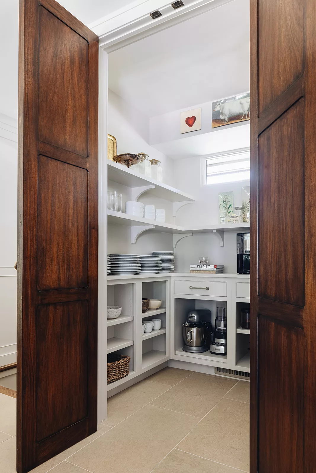 Walk-in pantry featuring pull-out shelves and labeled food storage bins